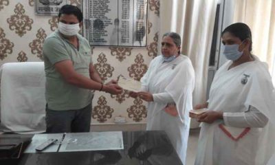 Brahma Kumaris Tosham in-charge BK Manju handing over ₹31,000 relief cheque to SDM Sandeep Kumar for Haryana Corona Relief Fund