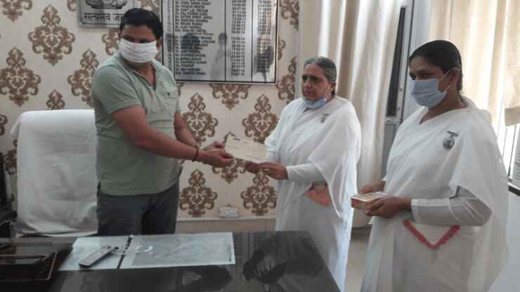 Brahma Kumaris Tosham in-charge BK Manju handing over ₹31,000 relief cheque to SDM Sandeep Kumar for Haryana Corona Relief Fund